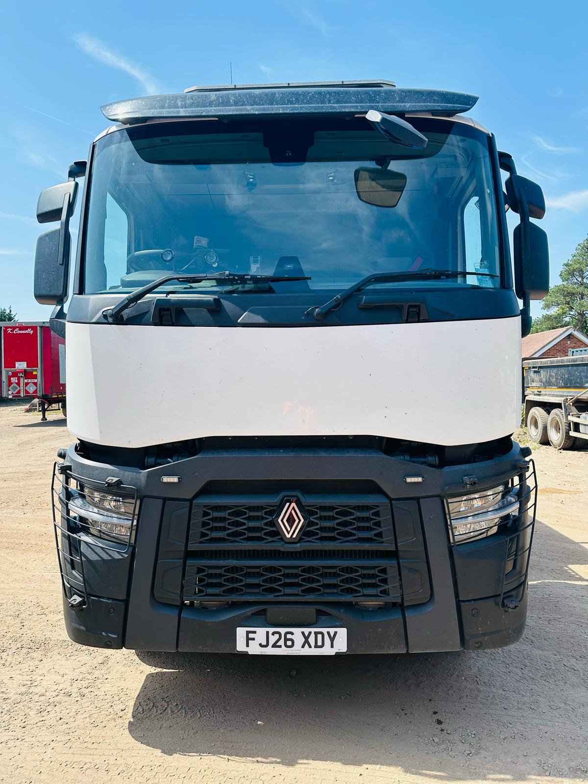Front view of a white Renault lorry in a yard on a sunny day